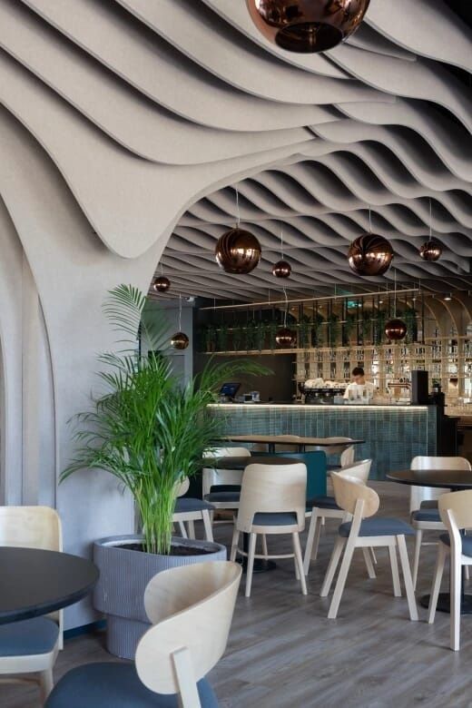 Modern restaurant with sculpted acoustic ceiling and pendant lights
