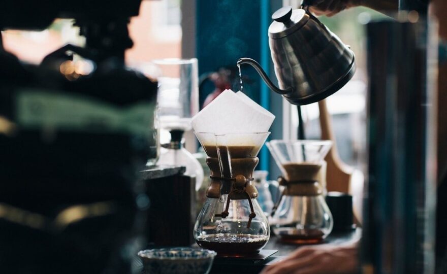 Barista pouring hot water over coffee grounds in a dripper