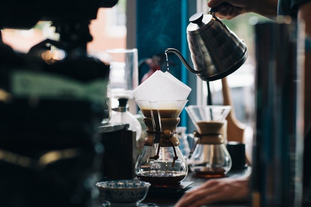 Barista pouring hot water over coffee grounds in a dripper