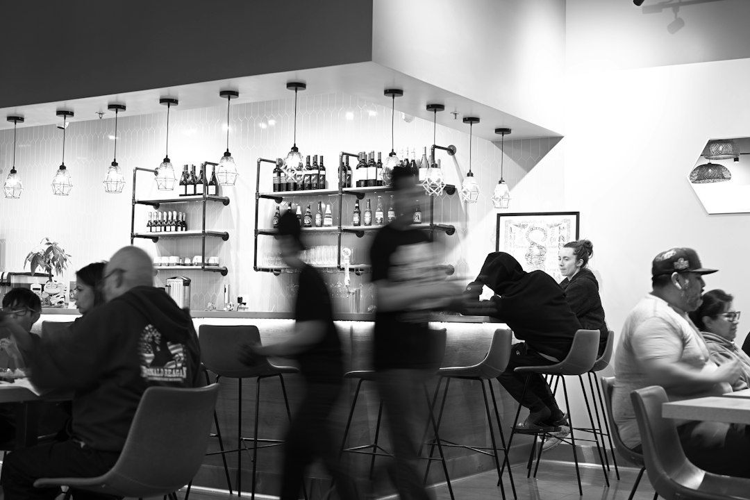 Busy restaurant interior with blurred movement and a visible bar area