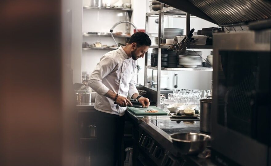 Chef preparing ingredients at a commercial kitchen workstation