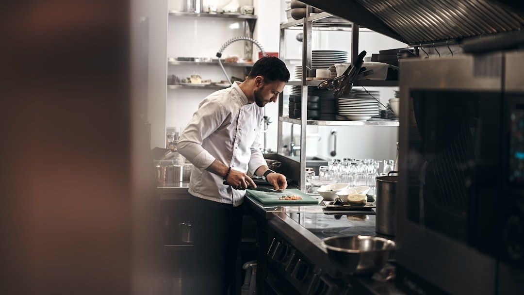 Chef preparing ingredients at a commercial kitchen workstation